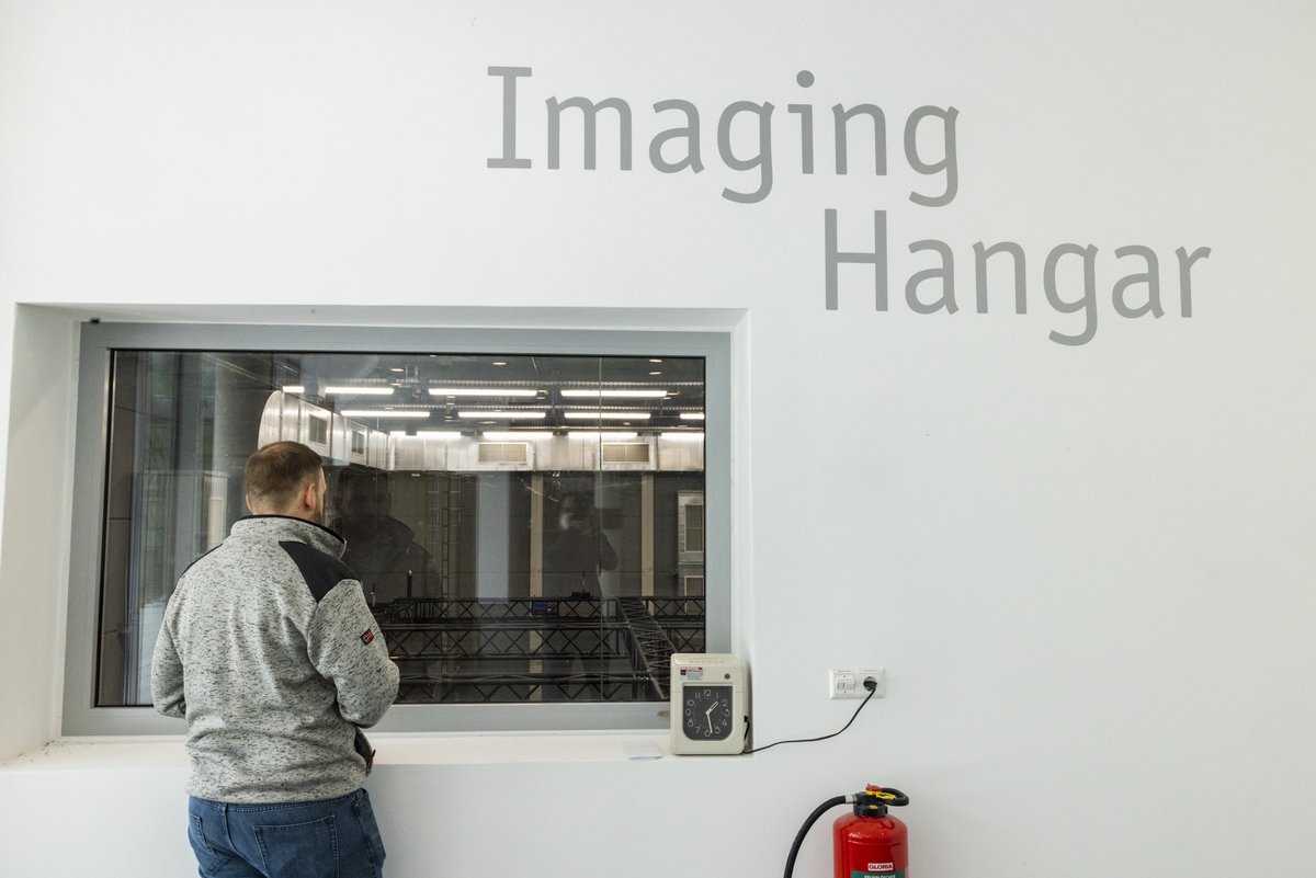 Besucherfenster Imaging Hangar mit Person davor.