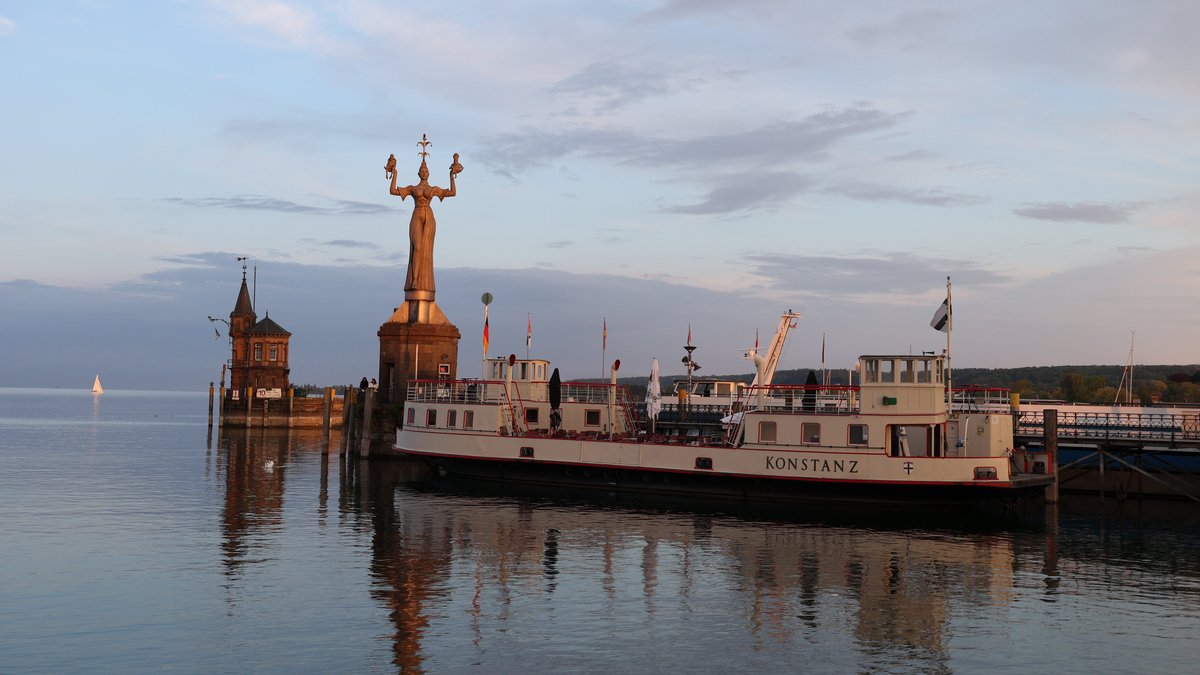 Konstanz harbour during sunset. An old ship, the Imperia stature.