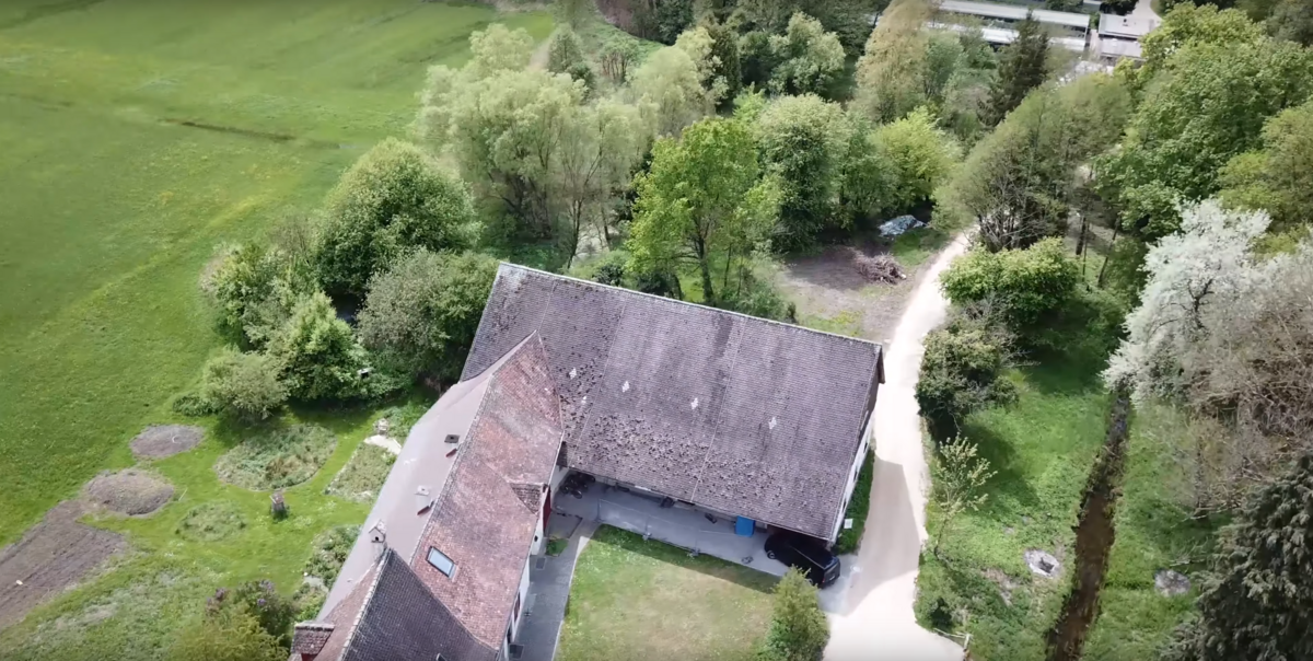Imaging Barn building from a bird perspective, green fields and trees around the building